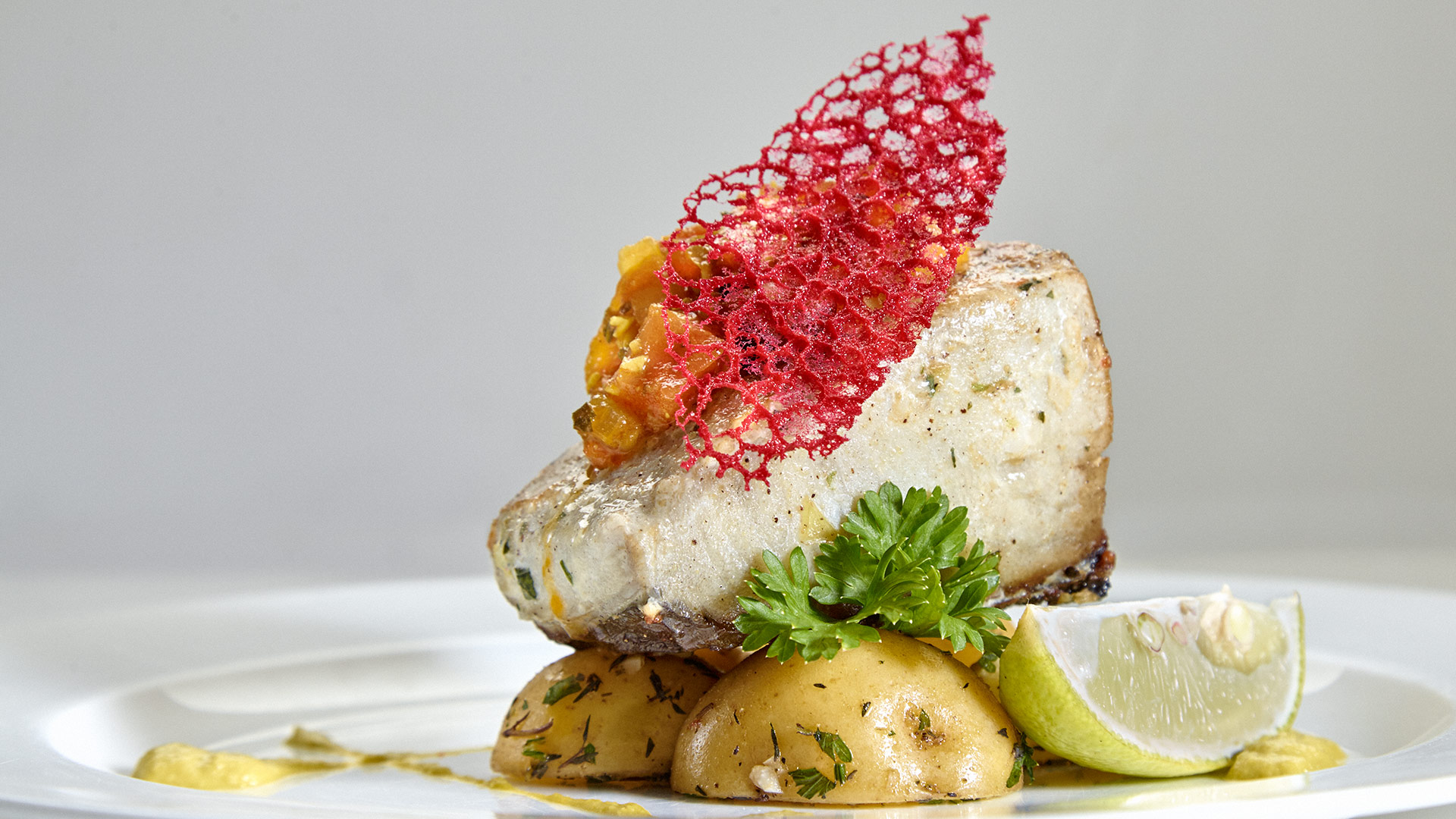 Butter basted King Fish napped with curried tomato concasse on Thyme infused fingerling potatoes & chive emulsion